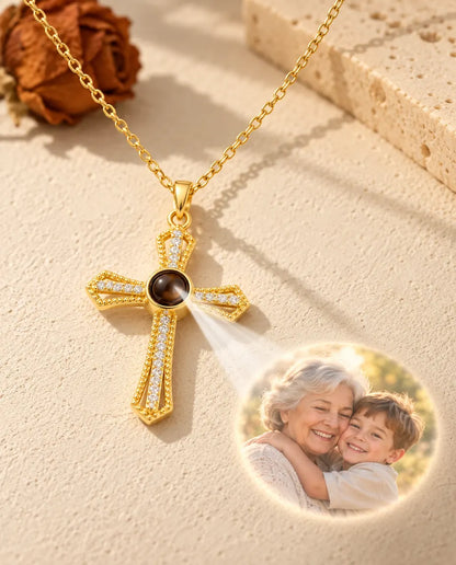 Light shining through the brown stone of the gold tone cross projects a photo of a grandmother hugging a boy