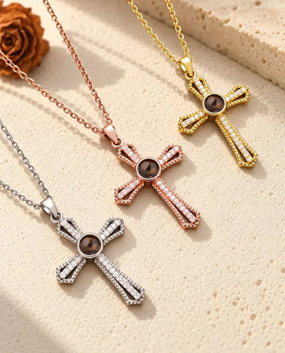 Pave cross projection necklaces in silver tone, rose gold tone and gold tone on a diagonal