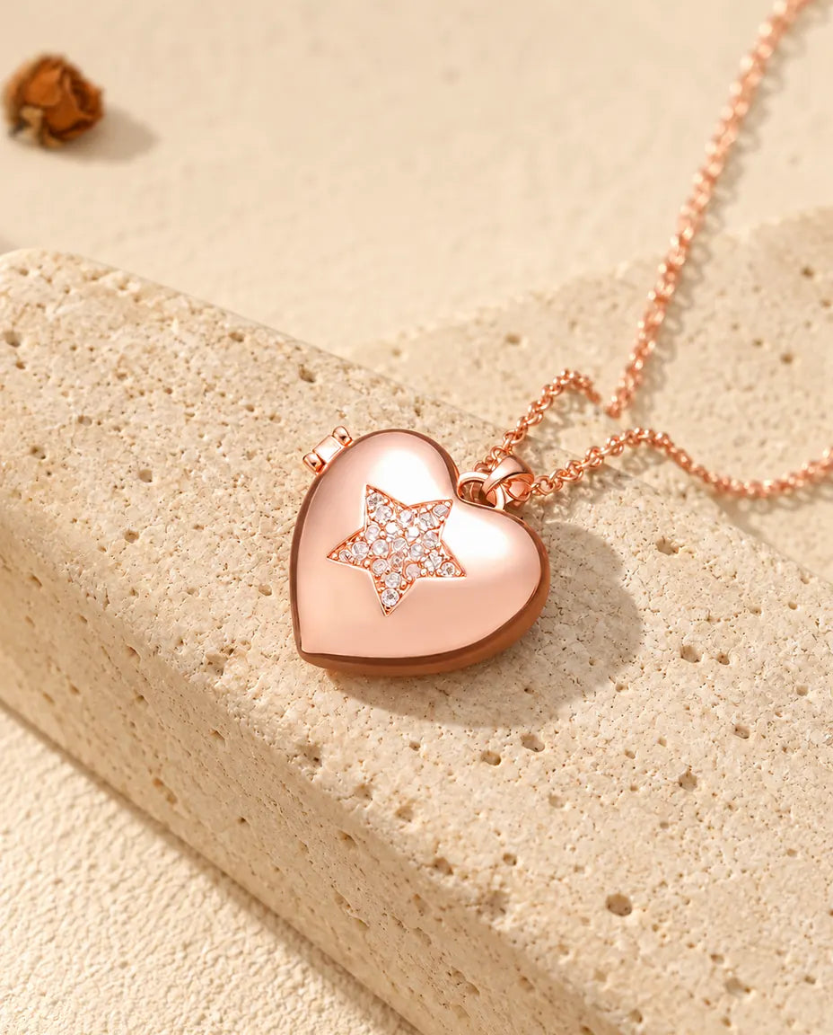 Rose gold tone pave star heart photo locket necklace on travertine in warm sunlight