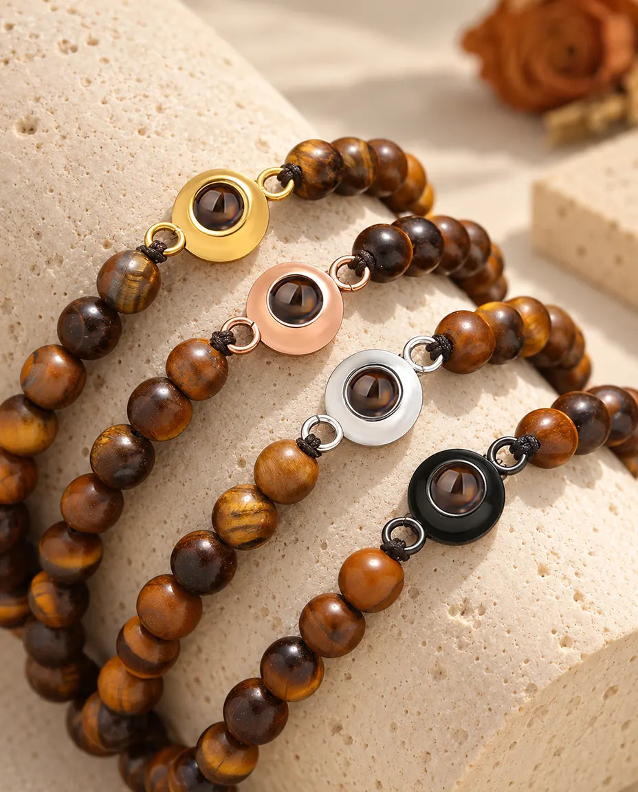 Tiger's eye bead projection bracelets in all four charm colours on a travertine block