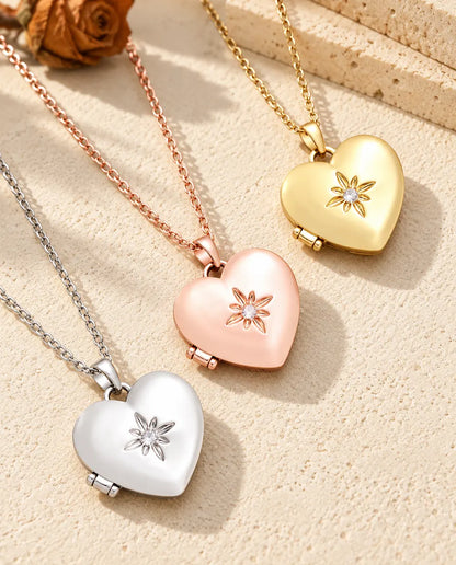 Satin flower heart photo lockets in silver tone, rose gold tone and gold tone laid diagonally on cream plaster