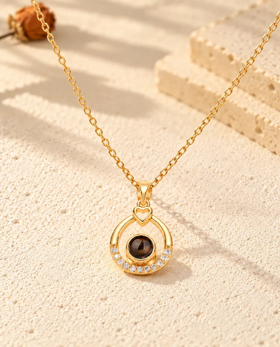 Front view of the gold tone open teardrop with a little heart and the projection stone