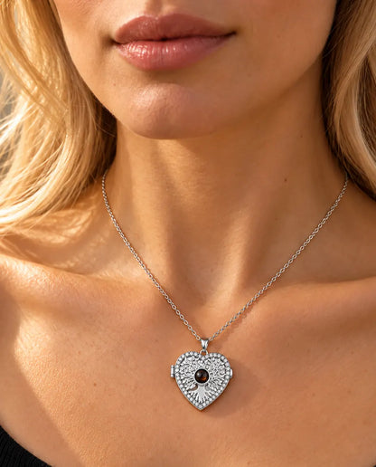 Woman in a black knit top wearing the silver tone tree of life heart projection locket necklace