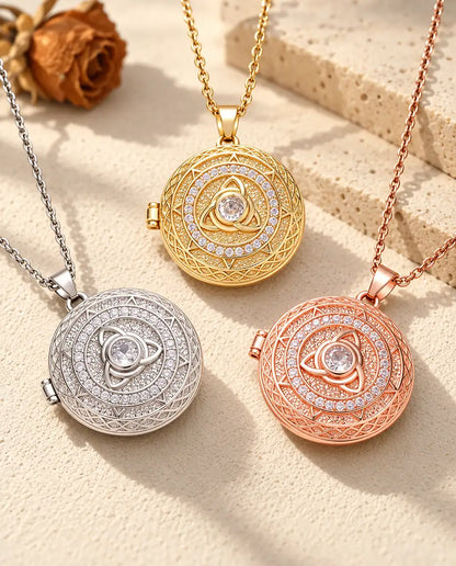Three colours of the trinity knot photo locket necklace arranged on plaster