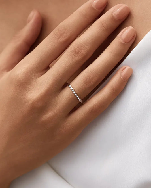 Studded Stacking Ring in 925 Sterling Silver - worn on a hand resting near the collarbone