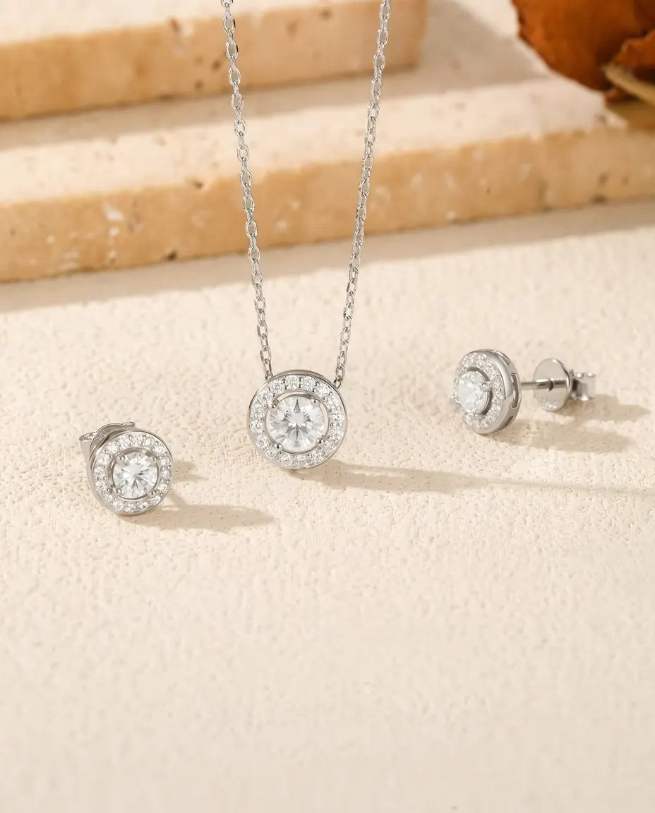 Round Moissanite Halo Jewellery Set in 925 Sterling Silver - the full set on a cream stone surface