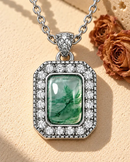 Rectangle Moss Agate Halo Necklace in 925 Sterling Silver - lying on a cream textured surface beside a travertine block