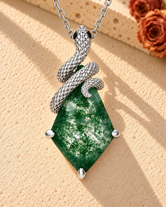 Snake Moss Agate Necklace in 925 Sterling Silver - lying on a cream textured surface beside a travertine block
