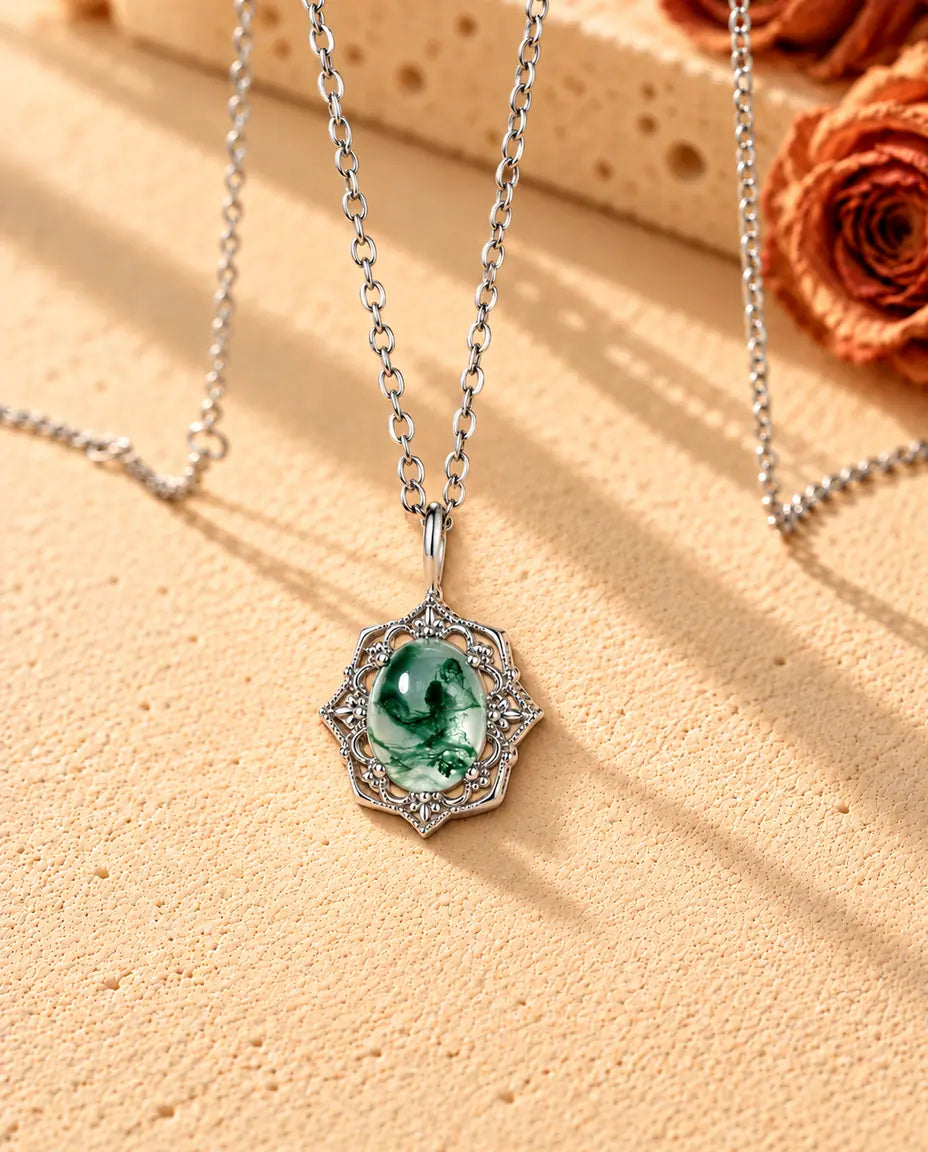 Vintage Moss Agate Pendant Necklace in 925 Sterling Silver - seen at an angle on a cream textured surface